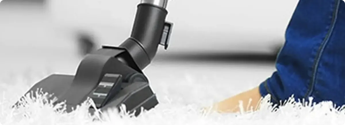 Close-up of a professional vacuuming a white carpet in Southaven.